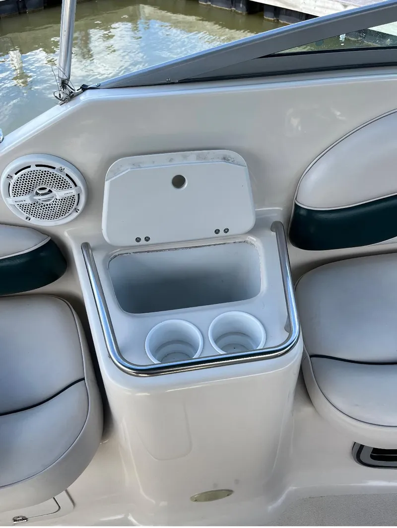 Slide: The Image of 2002 Crownline 242 CR boat interior with cup holders and storage compartment. - 2