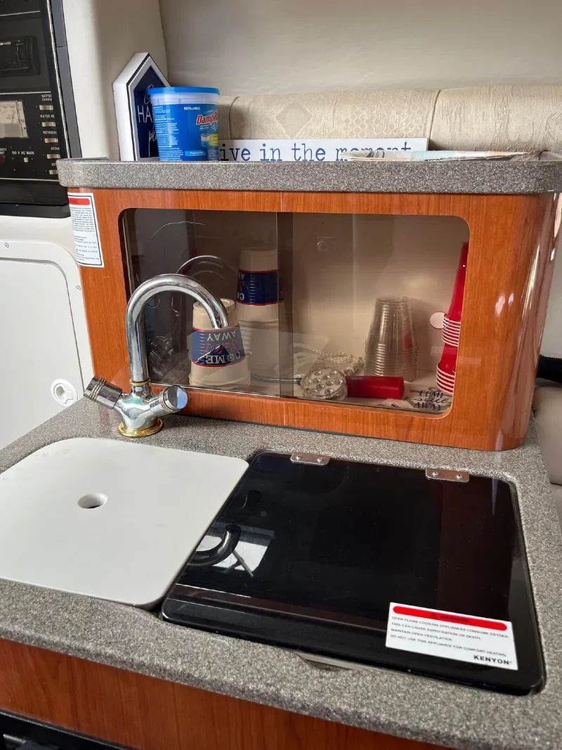 Slide: The Image of 2002 Crownline 242 CR boat kitchenette with sink and storage cabinet. - 7