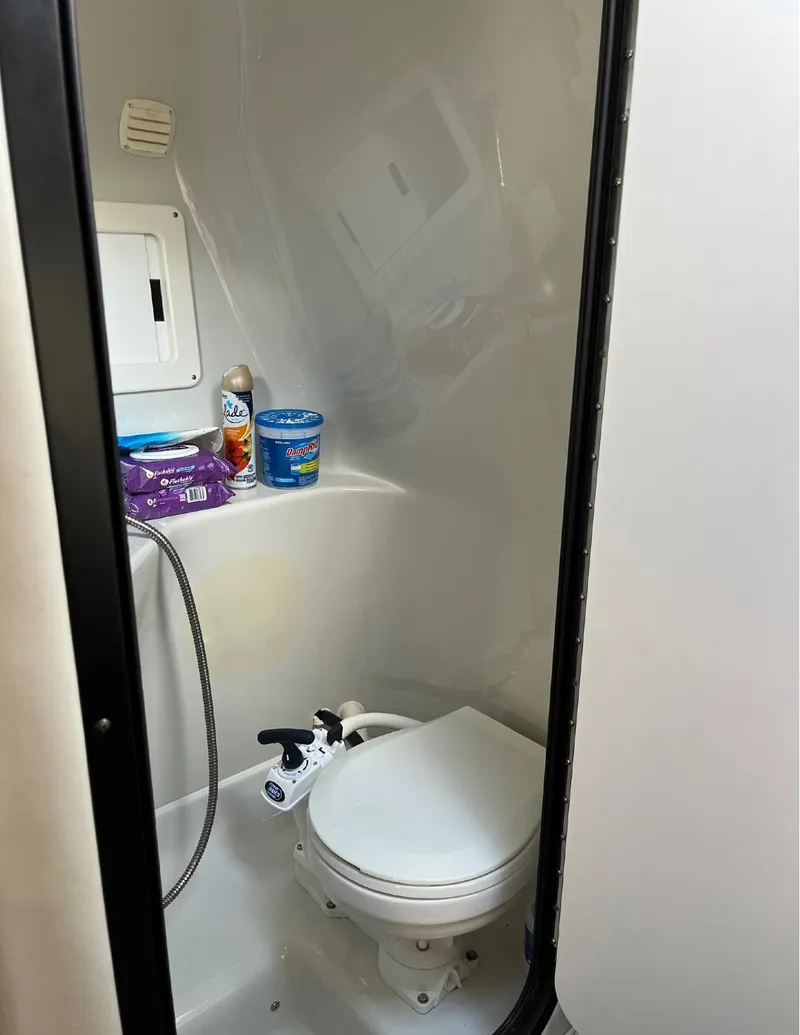 Slide: The Image of 2002 Crownline 242 CR boat bathroom with toilet and storage shelf. - 9