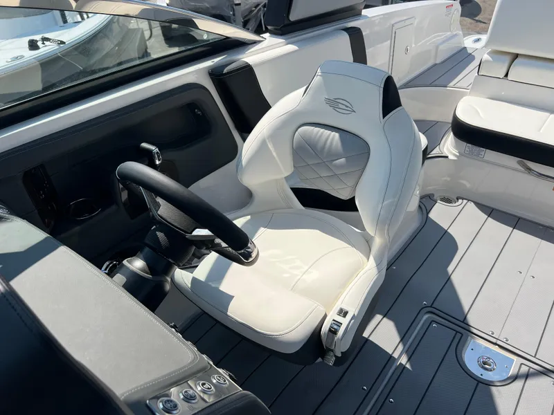 Slide: The Image of 2024 Chaparral 270 OSX boat cockpit with white captain's chair and steering wheel. - 14