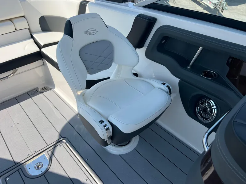 Slide: The Image of 2024 Chaparral 270 OSX boat interior with white captain's chair and modern design. - 15