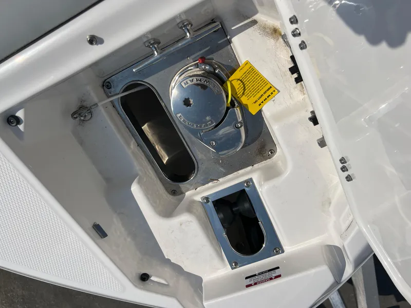 Slide: The Image of 2024 Chaparral 270 OSX boat fuel compartment with cap and safety tag. - 18