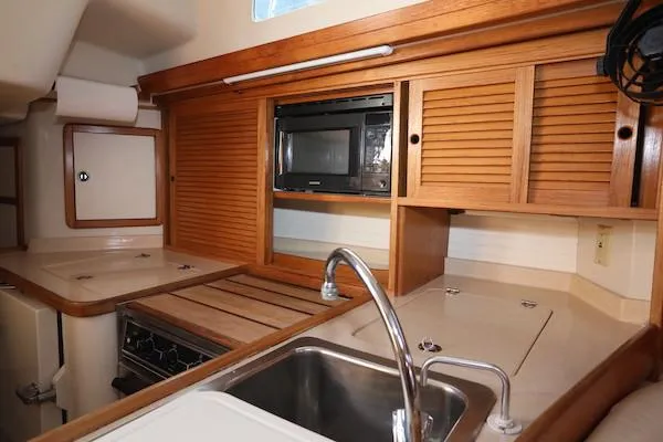 Slide: The Image of 2002 Catalina 42 MK 2 yacht kitchen with wood cabinets and stainless steel sink. - 14