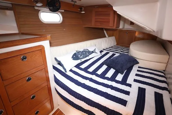 Slide: The Image of Cozy cabin interior of 2002 Catalina 42 MK 2 sailboat with striped bedding and wooden cabinetry. - 16