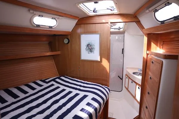 Slide: The Image of Interior of 2002 Catalina 42 MK 2 sailboat cabin with striped bedding and wooden finish. - 21