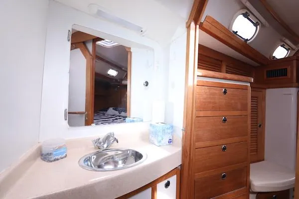 Slide: The Image of 2002 Catalina 42 MK 2 yacht interior with wooden cabinetry and bathroom sink. - 23