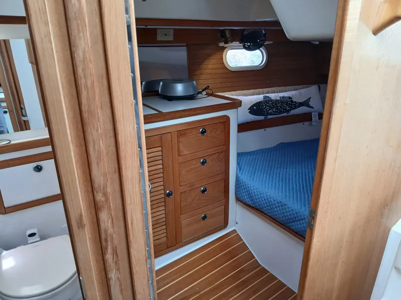 Slide: The Image of Interior cabin of a 2002 Catalina 42 MK 2 sailboat with wooden cabinetry and blue bedding. - 28