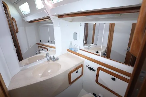 Slide: The Image of Catalina 42 MK 2 2002 yacht bathroom with sink, mirrors, and wooden accents. - 36