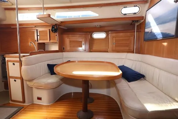 Slide: The Image of Interior of 2002 Catalina 42 MK 2 sailboat with cozy seating and wooden table. - 9