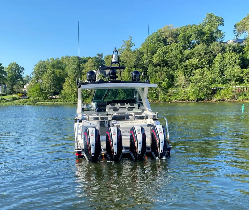 Slide: The Image of 2021 Formula 430 Super Sport Crossover boat on a lake with lush green trees. - 4