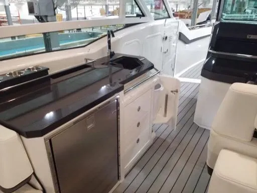 Slide: The Image of 2021 Formula 430 Super Sport Crossover yacht interior with kitchenette and seating area. - 7
