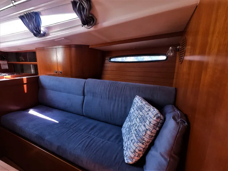 Slide: The Image of Interior of 2010 Finn Flyer 33 R sailboat with blue cushioned seating and wooden cabinetry. - 28