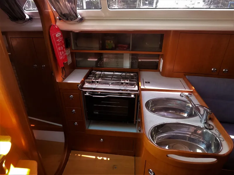 Slide: The Image of 2010 Finn Flyer 33 R yacht kitchen with stove, sink, and wooden cabinetry. - 29