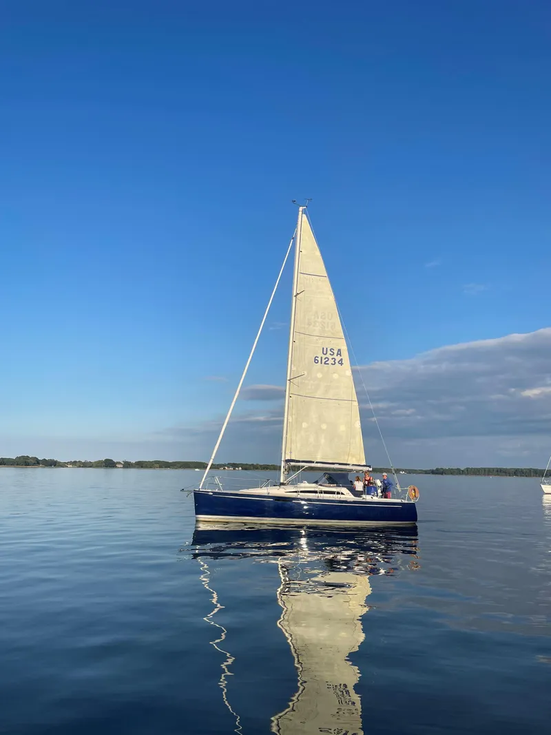 Slide: The Image of 2010 Finn Flyer 33 R sailboat on calm water under a clear blue sky. - 43
