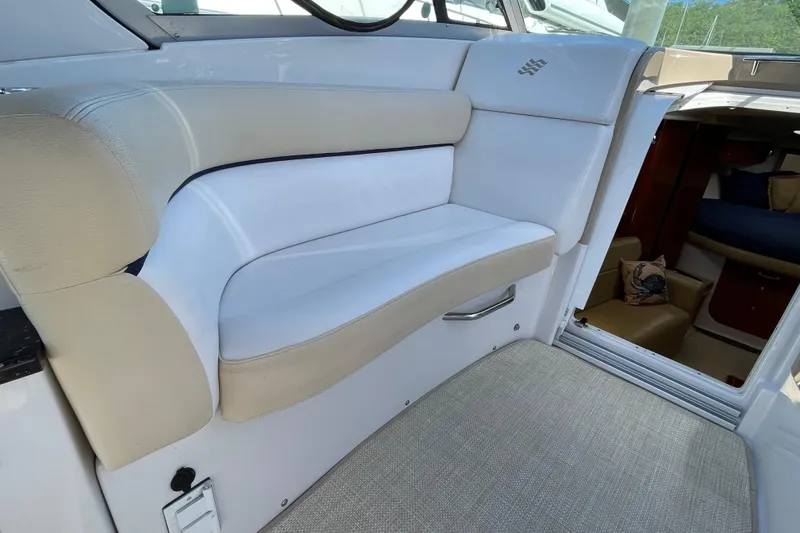 Slide: The Image of 2008 Four Winns V338 boat interior seating area with beige and white upholstery. - 11
