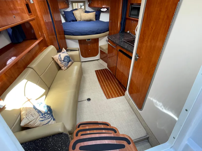 Slide: The Image of 2008 Four Winns V338 cabin interior with sofa, kitchenette, and bed. - 14