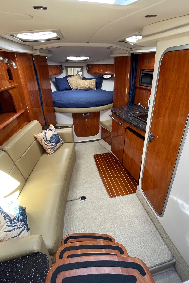 Slide: The Image of 2008 Four Winns V338 yacht interior with cozy seating, kitchenette, and sleeping area. - 15