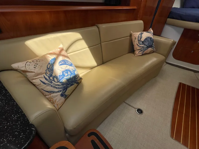 Slide: The Image of 2008 Four Winns V338 interior with beige leather sofa and crab-themed pillows. - 18