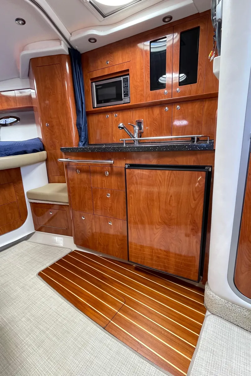 Slide: The Image of 2008 Four Winns V338 yacht interior kitchen with wood cabinetry, microwave, and mini-fridge. - 19