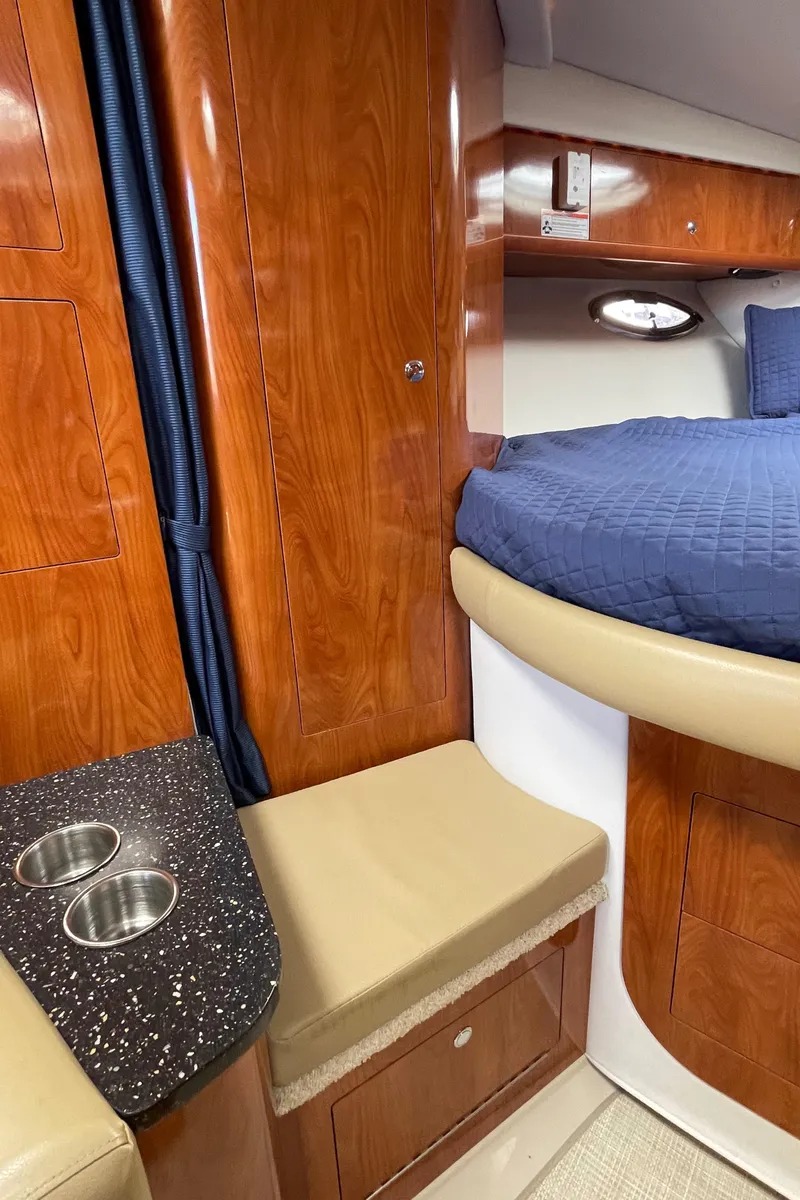 Slide: The Image of 2008 Four Winns V338 cabin interior with wood finish, bed, and seating area. - 22