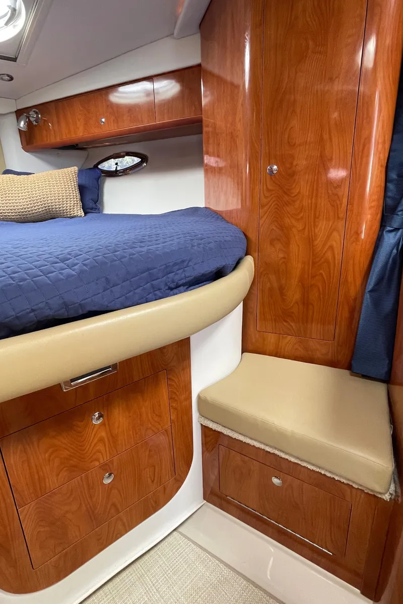 Slide: The Image of 2008 Four Winns V338 cabin interior with wooden cabinetry and blue bedding. - 23