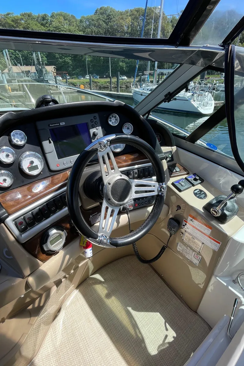 Slide: The Image of 2008 Four Winns V338 boat cockpit with steering wheel and control panel. - 34