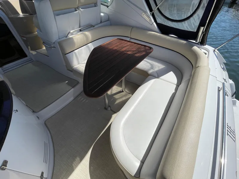Slide: The Image of 2008 Four Winns V338 boat interior with white leather seating and wooden table. - 8