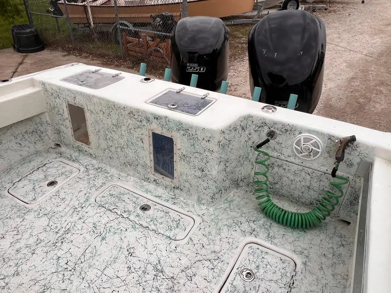 Slide: The Image of 1978 Excalibur 32 boat deck with twin outboard motors and green coiled hose. - 19