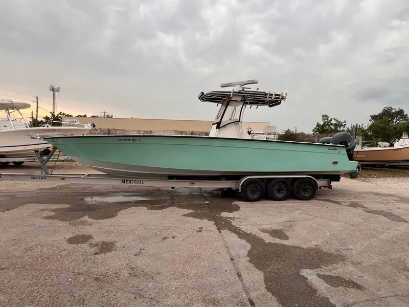 Slide: The Image of 1978 Excalibur 32 boat on a trailer in a parking lot. - 2