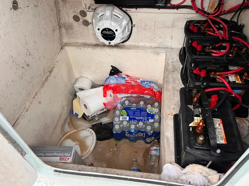 Slide: The Image of Storage compartment of a 1978 Excalibur 32 boat with batteries and supplies. - 26