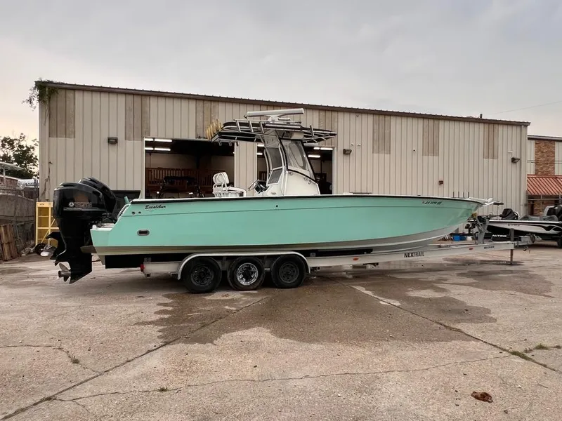 Slide: The Image of 1978 Excalibur 32 boat on a trailer in front of a warehouse. - 6
