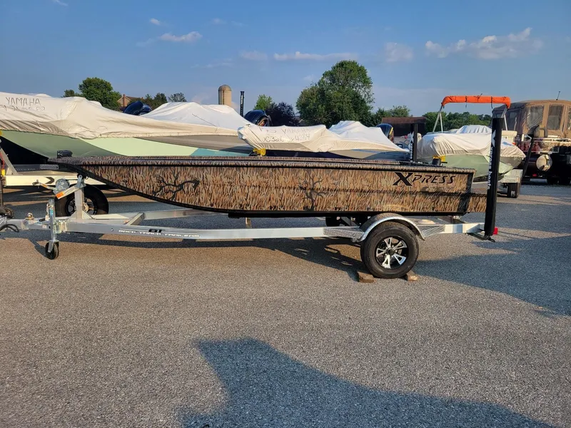 The Image of 2025 Xpress XTS16 duck hunting boat with Yamaha 25 hp engine on trailer. - 1
