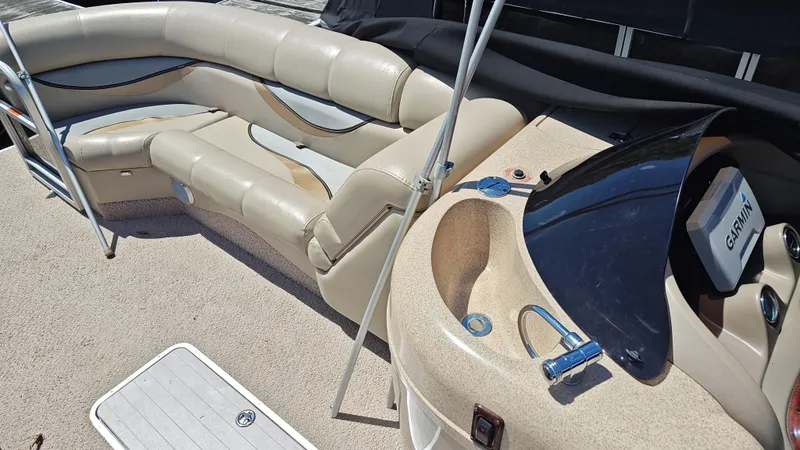 Slide: The Image of 2011 South Bay 722CR boat interior with beige seating and Garmin navigation system. - 12