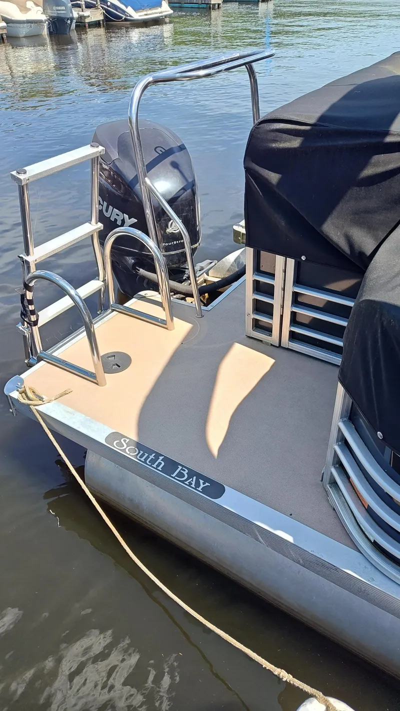 Slide: The Image of 2011 South Bay 722CR pontoon boat with Mercury outboard motor docked at marina. - 7