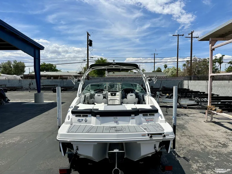 Slide: The Image of 2022 Chaparral 23 Surf boat in a parking lot, rear view. - 11