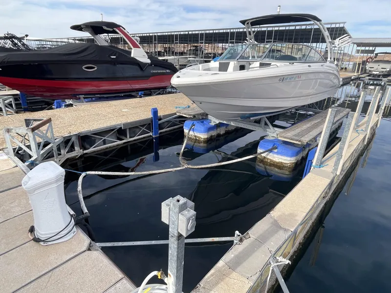 Slide: The Image of 2022 Chaparral 23 Surf boat docked at marina with lift system. - 14