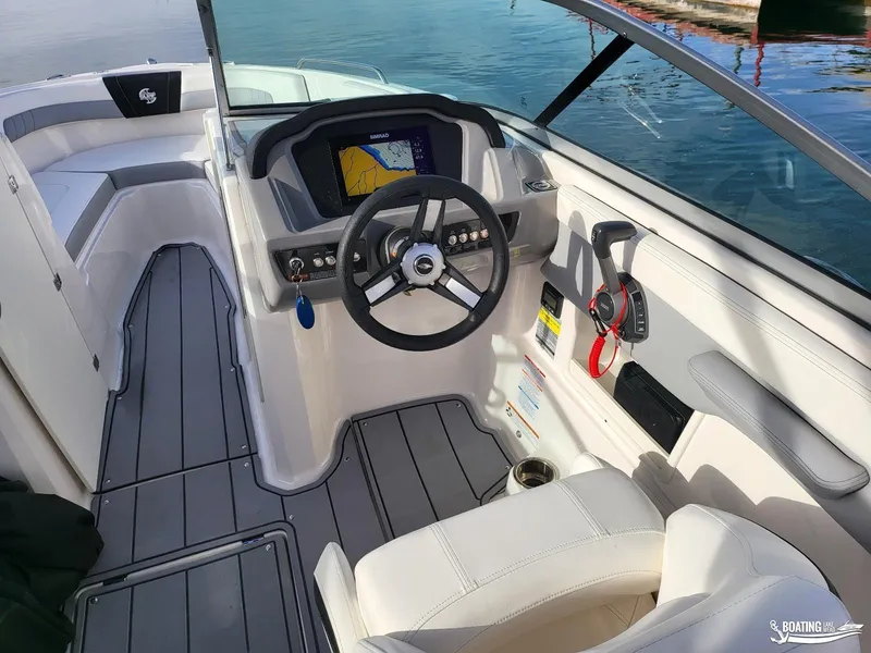 Slide: The Image of 2022 Chaparral 23 Surf boat interior with steering wheel and navigation display. - 18