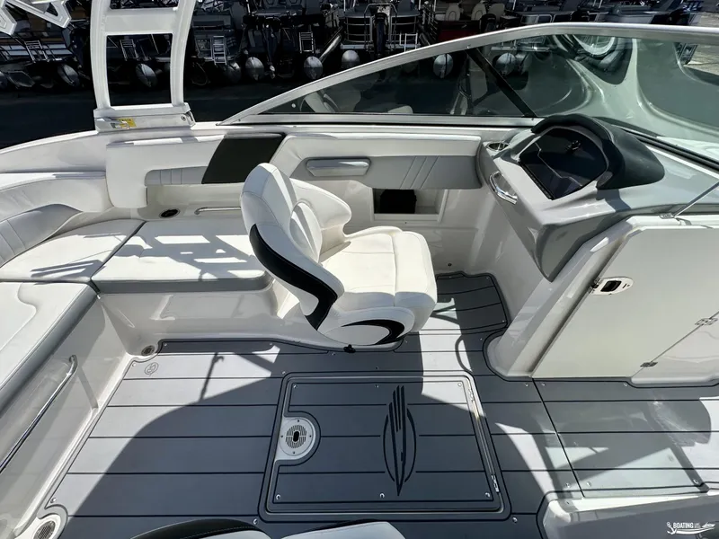 Slide: The Image of 2022 Chaparral 23 Surf boat interior with white seating and modern dashboard. - 21