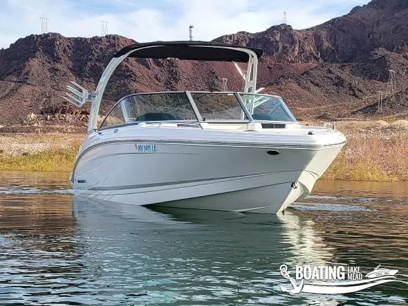 Slide: The Image of 2022 Chaparral 23 Surf boat on water with rocky hills in background. - 3