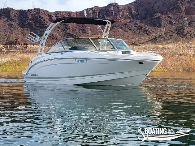 Slide: The Image of 2022 Chaparral 23 Surf boat on a lake with rocky hills in the background. - 4