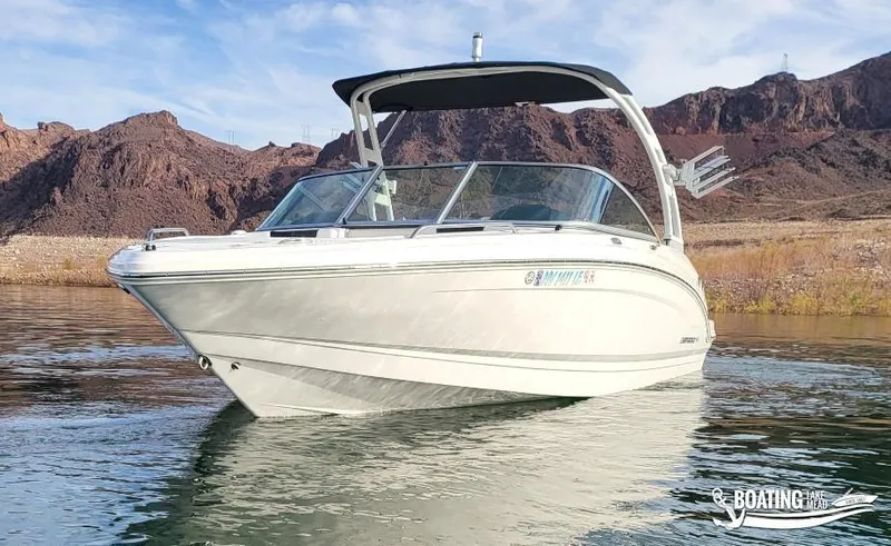 Slide: The Image of 2022 Chaparral 23 Surf boat on a lake with rocky hills in the background. - 5