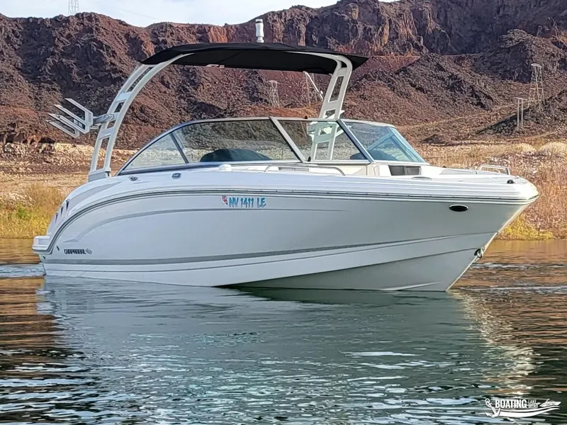 Slide: The Image of 2022 Chaparral 23 Surf boat on water with rocky background. - 7