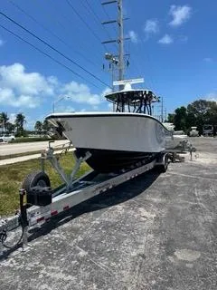 The Image of 2024 Yellowfin 32CC Offshore boat on a trailer under a clear blue sky. - 1