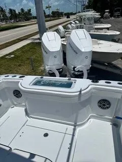 Slide: The Image of 2024 Yellowfin 32CC OFFSHORE boat with twin Mercury engines, docked near a road. - 5