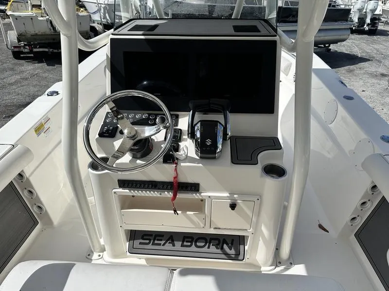 Slide: The Image of 2023 Sea Born FX24 Bay LE boat console with steering wheel and controls. - 2