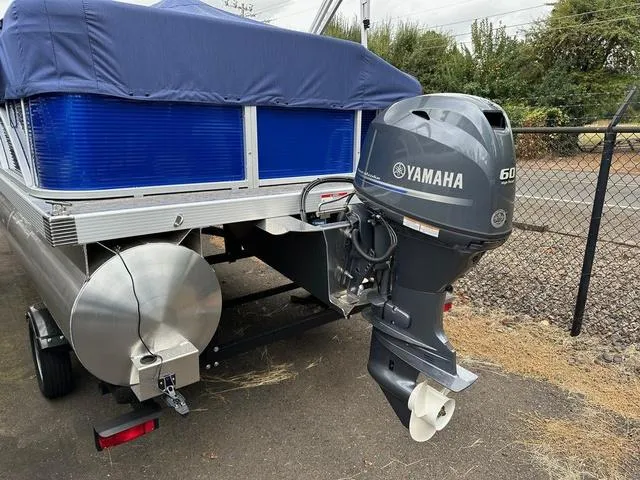 Slide: The Image of 2025 Bennington 188 SVL pontoon boat with Yamaha 60 outboard motor, parked on trailer. - 2