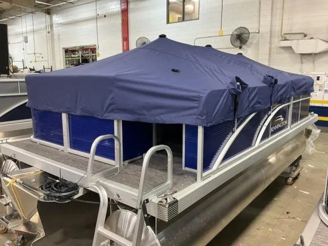 Slide: The Image of 2025 Bennington 188 SVL pontoon boat with blue cover in a warehouse setting. - 22