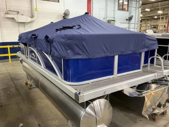 Slide: The Image of 2025 Bennington 188 SVL pontoon boat with blue cover in a warehouse setting. - 23
