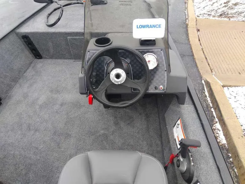 Slide: The Image of 2024 Tracker Bass Tracker Classic XL boat interior with steering wheel and Lowrance fish finder. - 2