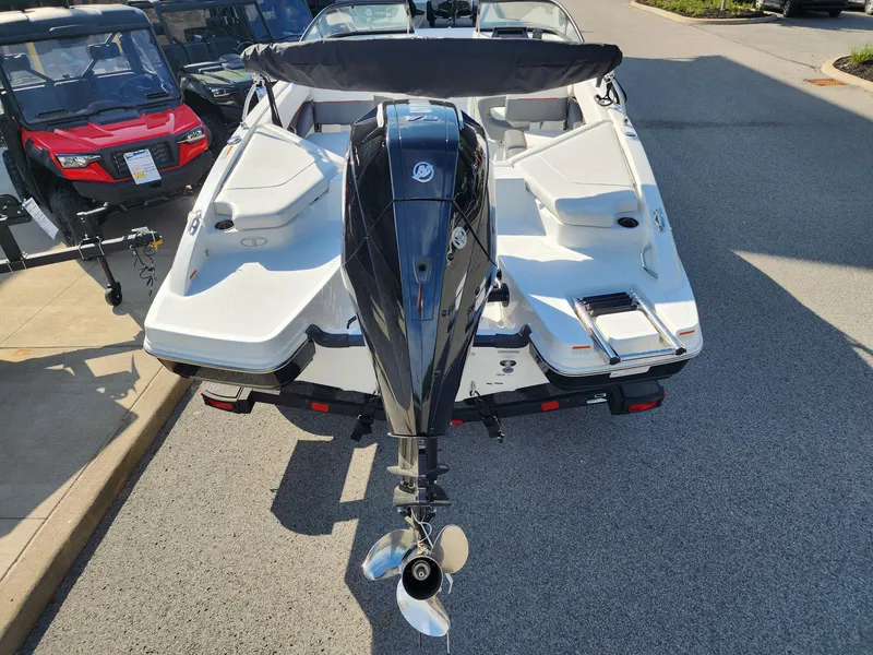 Slide: The Image of 2024 Tahoe 210 S boat with outboard motor, parked on pavement. - 3
